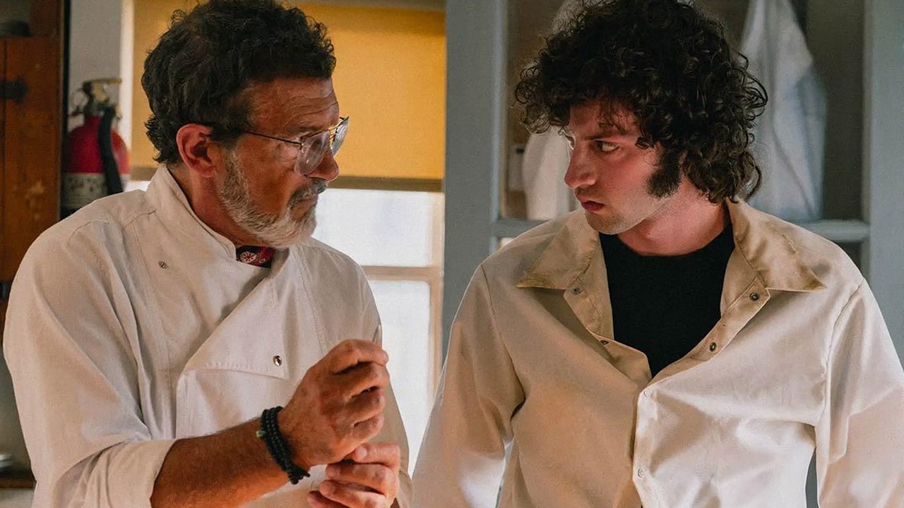 Dominic Sessa as Anthony Bourdain and Antonio Banderas as 'Chef' in a serious still from the biographical film Tony.